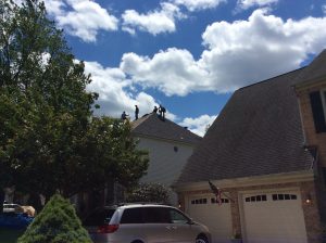 workers on top of neighbor roof 