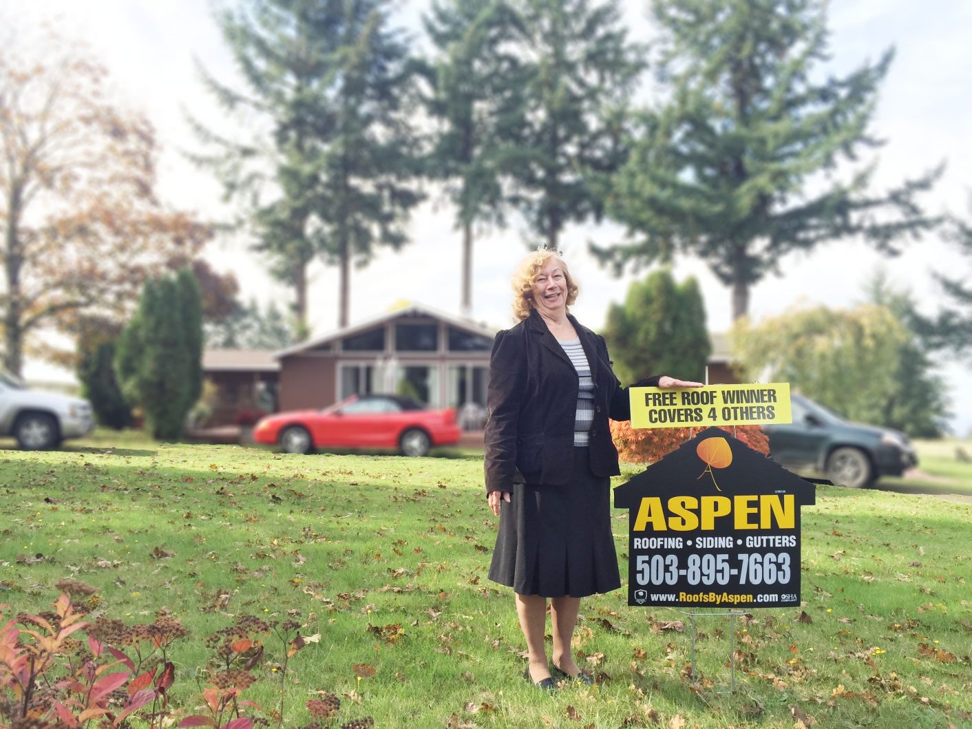 Homeowner standing by Aspen house sign