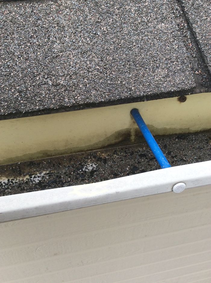 When granules are seen in the gutter as pictured here it might be a sign to replace your shingles